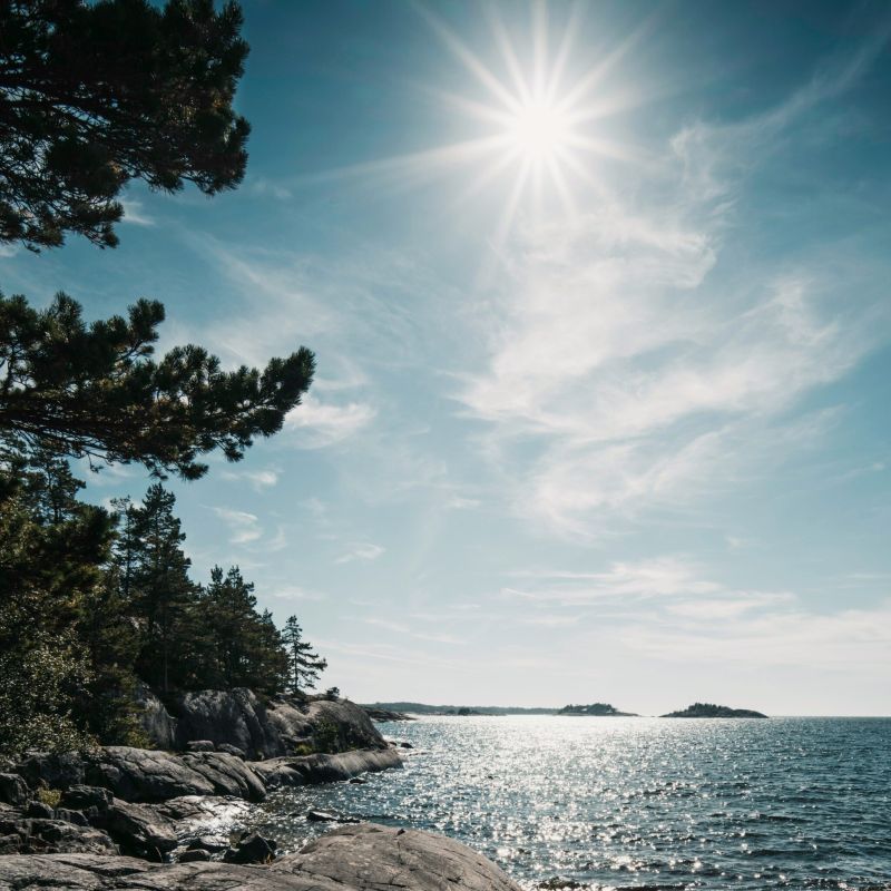 Klippor ut över havet där solen lyser.