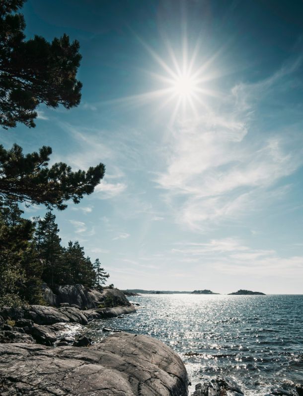 Klippor ut över havet där solen lyser.